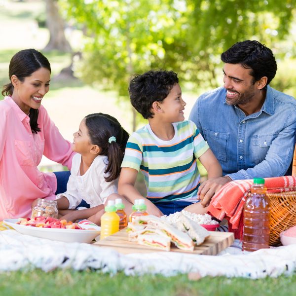Happy family having breakfast in a park