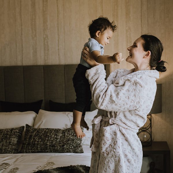 Mother holding baby in a bedroom